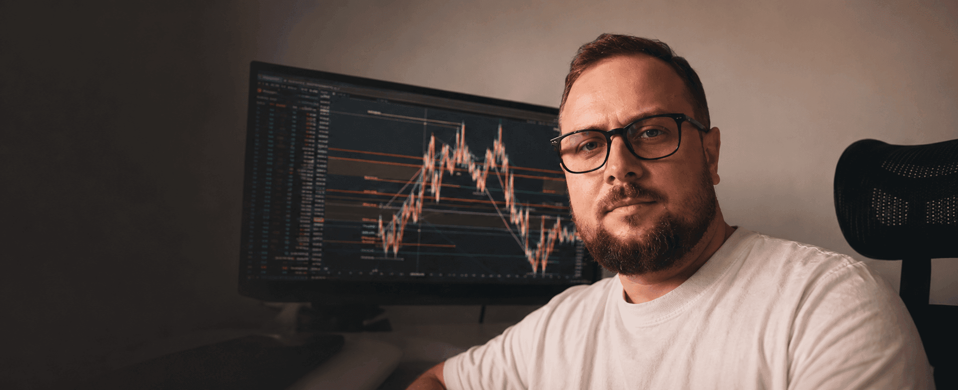 Ned Zimin at his desk in front of a live trading chart